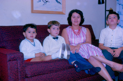 Roberto with mother and brothers on sofa in 1963